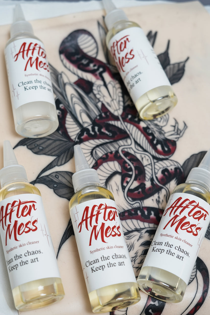 Five bottles of 'After Mess' on a tattooed surface