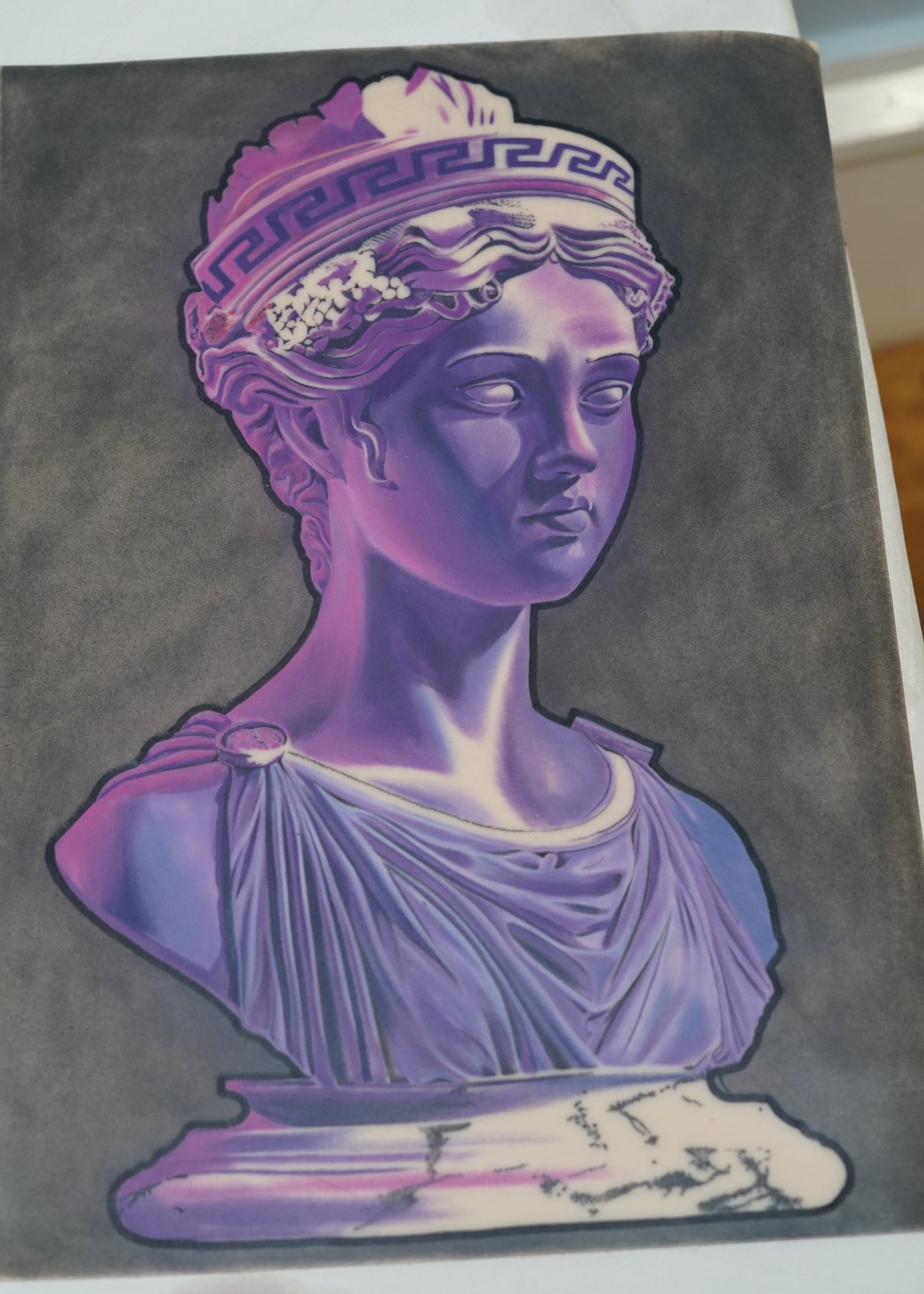Decorative book with a purple and white classical statue design on a dark background