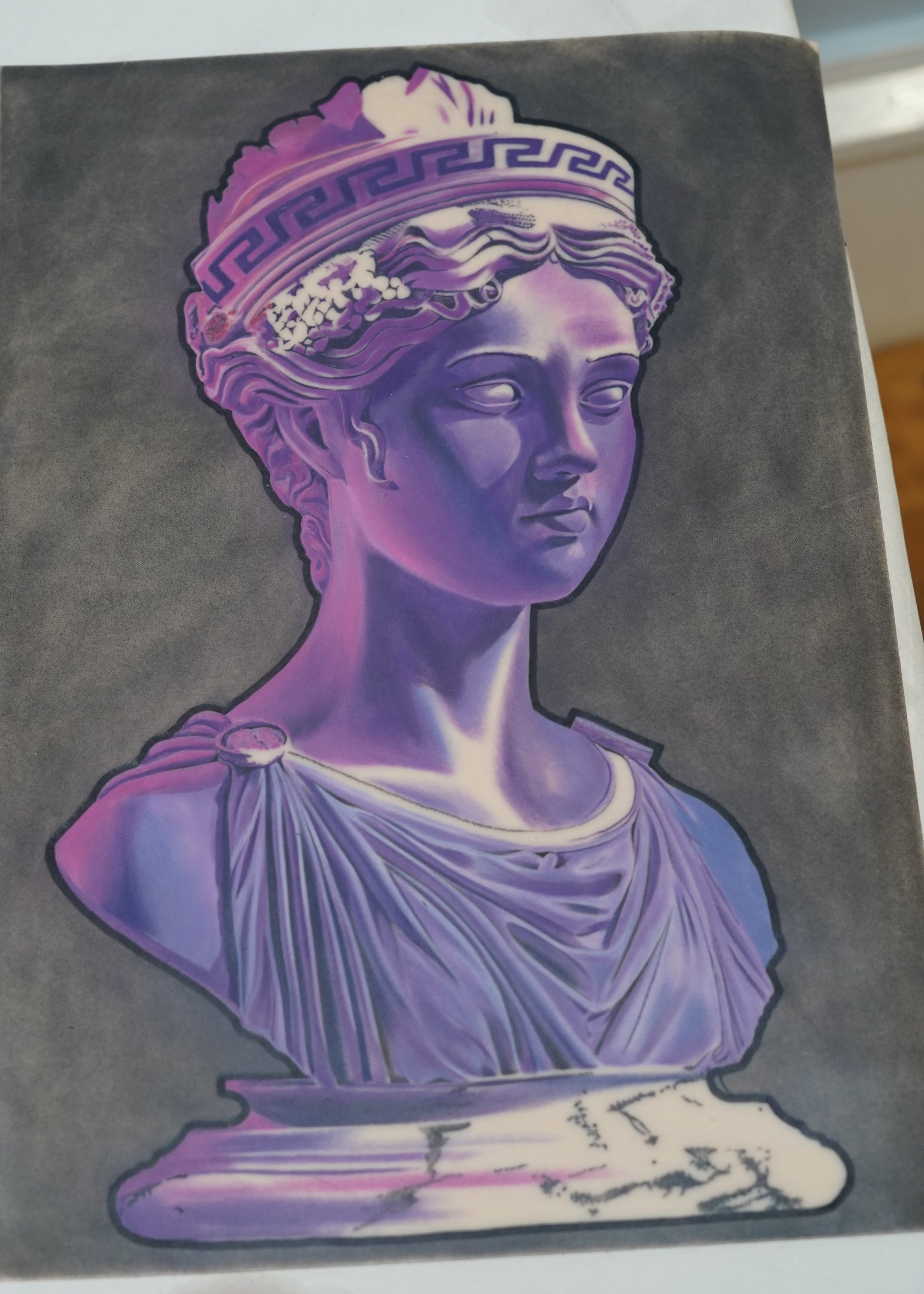 Decorative book with a purple and white classical statue design on a dark background